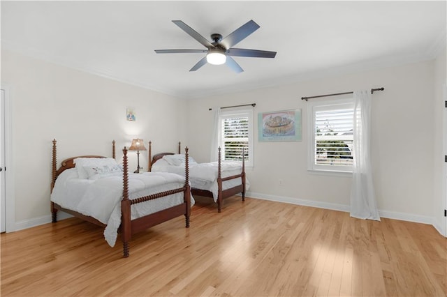 bedroom featuring ornamental molding, ceiling fan, and light wood-type flooring