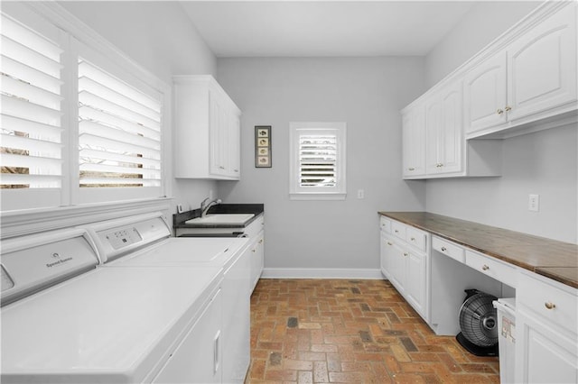 laundry area with sink, washing machine and dryer, and cabinets