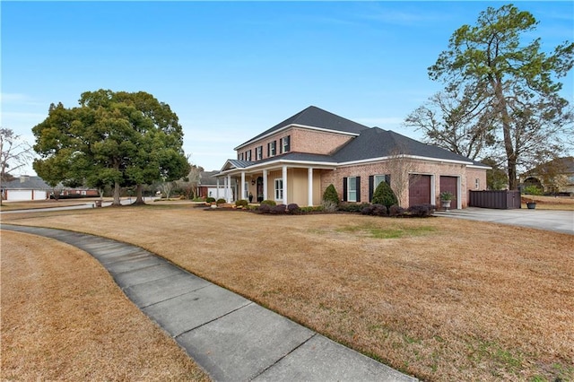 view of front of home featuring a porch, a garage, and a front lawn