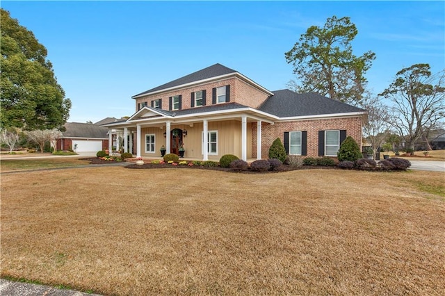 view of front of property with a garage, covered porch, and a front yard