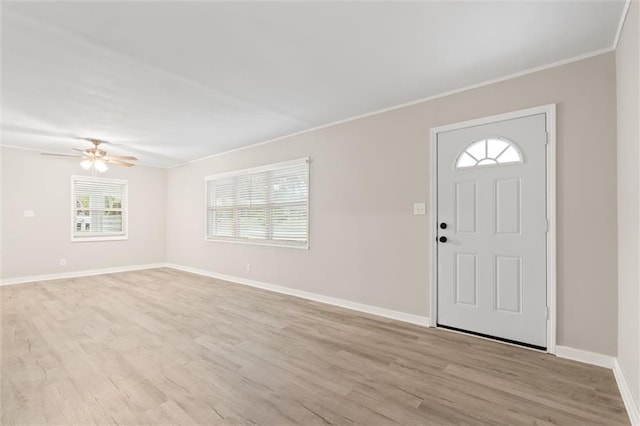 foyer entrance with light wood-type flooring, ceiling fan, and ornamental molding