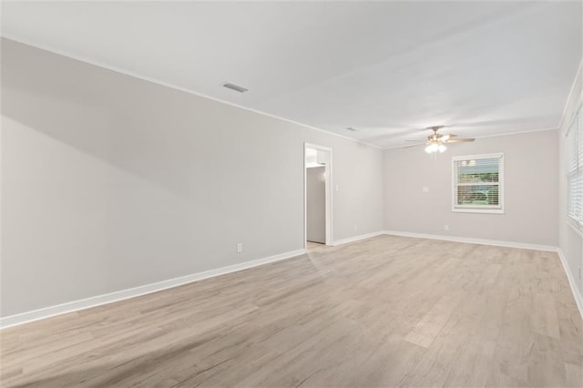 empty room with ceiling fan, light wood-type flooring, and crown molding