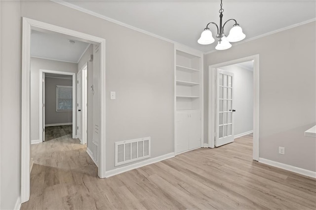 unfurnished dining area with light hardwood / wood-style floors, crown molding, and a chandelier