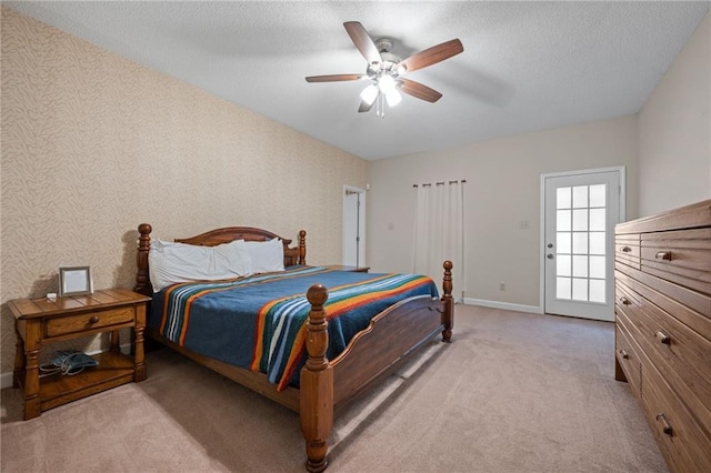 bedroom with ceiling fan, light colored carpet, and a textured ceiling