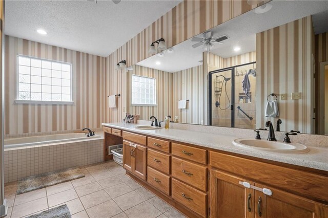 bathroom with a textured ceiling, ceiling fan, tile patterned floors, a healthy amount of sunlight, and vanity