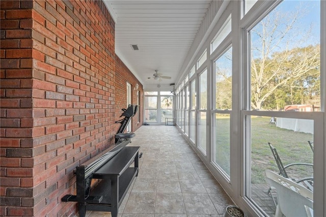 unfurnished sunroom with ceiling fan