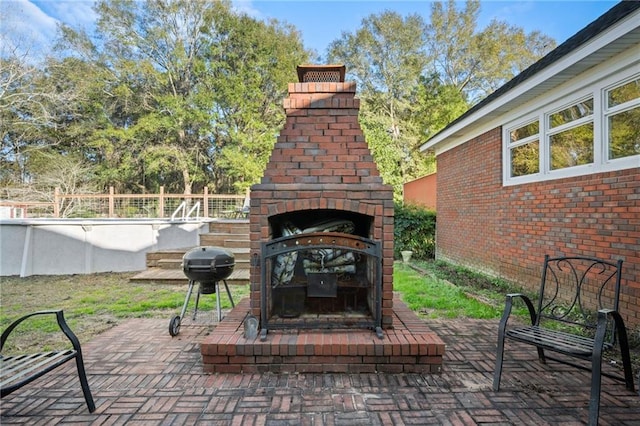 view of patio / terrace featuring an outdoor brick fireplace and grilling area