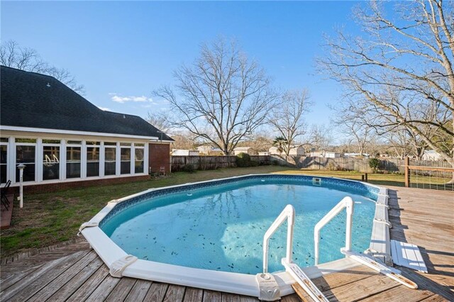 view of pool featuring a deck and a sunroom