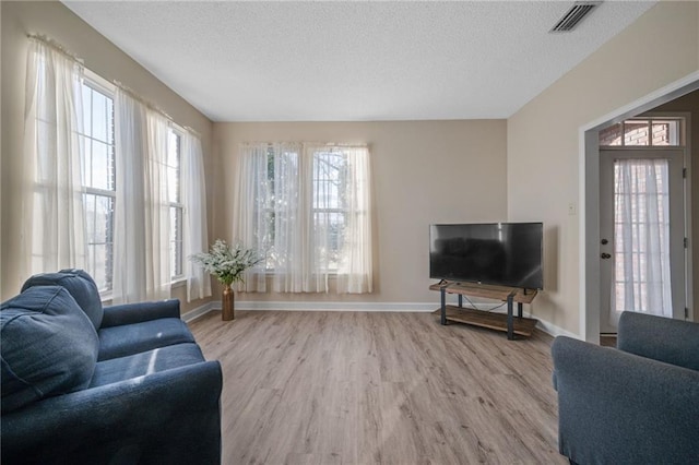 living room featuring a textured ceiling and light hardwood / wood-style flooring