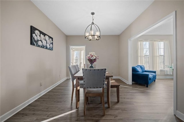 dining space featuring a notable chandelier and dark hardwood / wood-style flooring