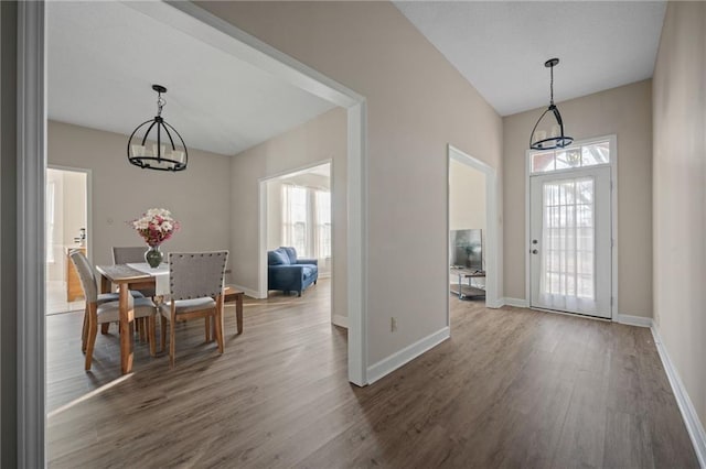 dining room with dark wood-type flooring, an inviting chandelier, and a wealth of natural light