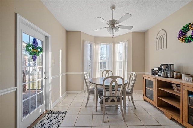 dining area with a textured ceiling, ceiling fan, and light tile patterned floors