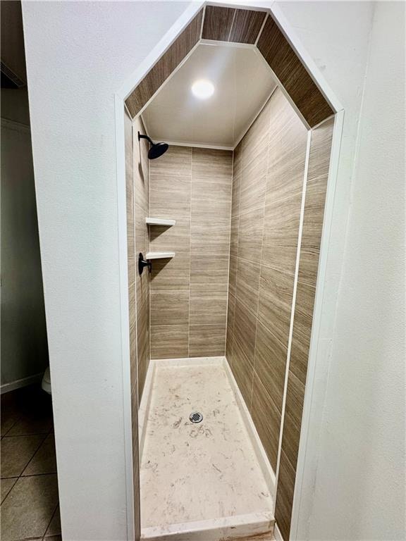 bathroom with tile patterned flooring and tiled shower