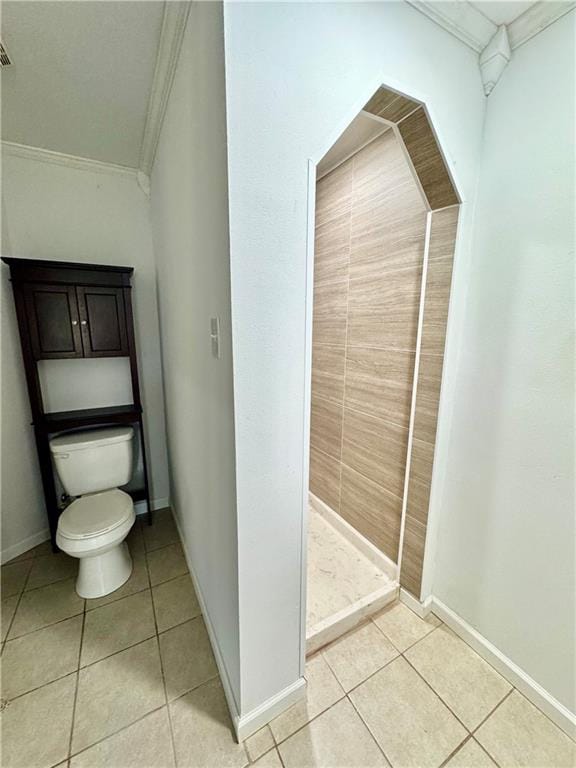 bathroom with tile patterned floors, crown molding, a shower, and toilet