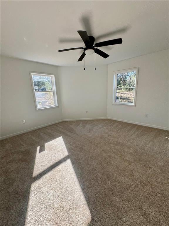 carpeted empty room with a wealth of natural light and ceiling fan