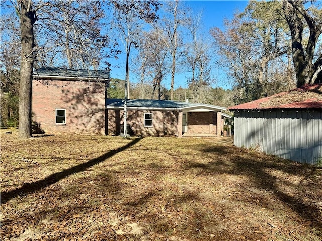 rear view of property with a yard and a carport