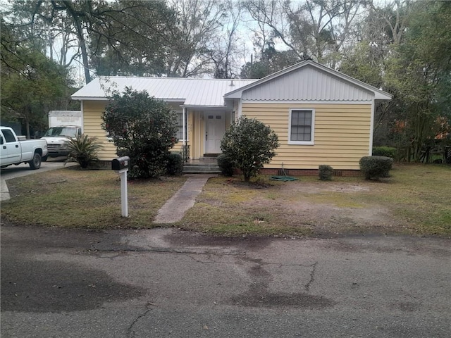 view of front of house featuring driveway and metal roof