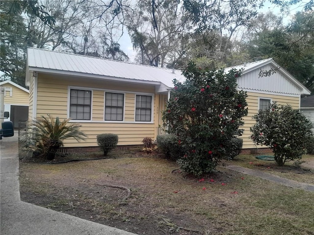 view of front of house with crawl space and metal roof