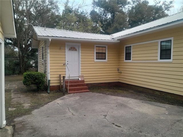 view of exterior entry featuring metal roof