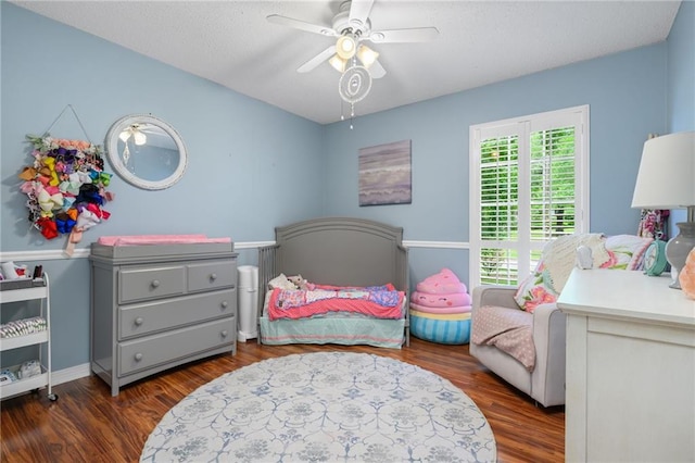 bedroom with a textured ceiling, ceiling fan, and wood finished floors