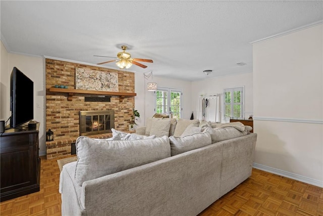 living room with a brick fireplace, ceiling fan, crown molding, and baseboards