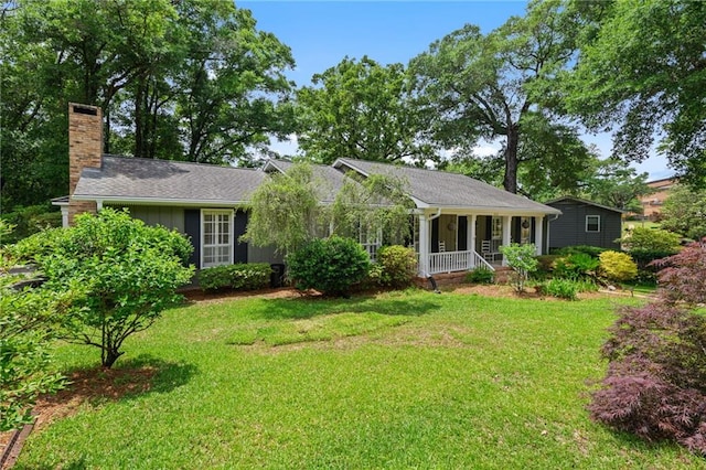 ranch-style house with a porch, board and batten siding, a front yard, and a chimney