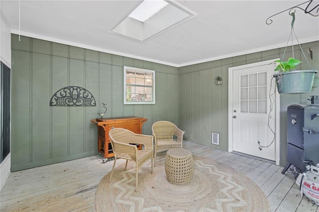 sitting room with wood finished floors and a skylight