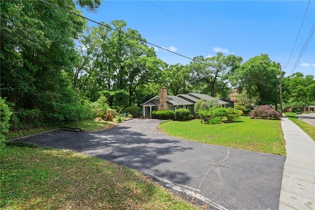view of front of house featuring a chimney and a front yard