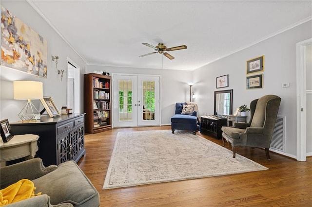 sitting room featuring french doors, a ceiling fan, visible vents, wood finished floors, and ornamental molding