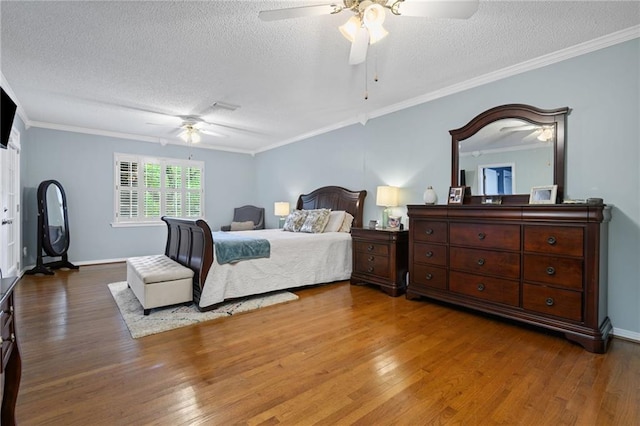 bedroom with ceiling fan, a textured ceiling, ornamental molding, and wood finished floors