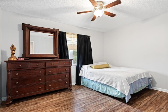 bedroom with ceiling fan, a textured ceiling, baseboards, and wood finished floors