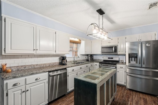 kitchen featuring visible vents, white cabinets, a kitchen island, stainless steel appliances, and a sink