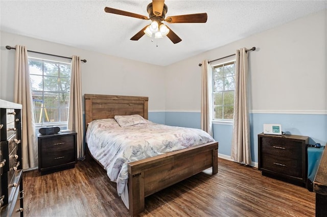 bedroom with a textured ceiling, baseboards, and dark wood-style flooring