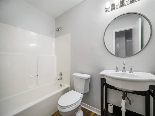 bathroom with toilet, hardwood / wood-style floors, and shower / bathing tub combination