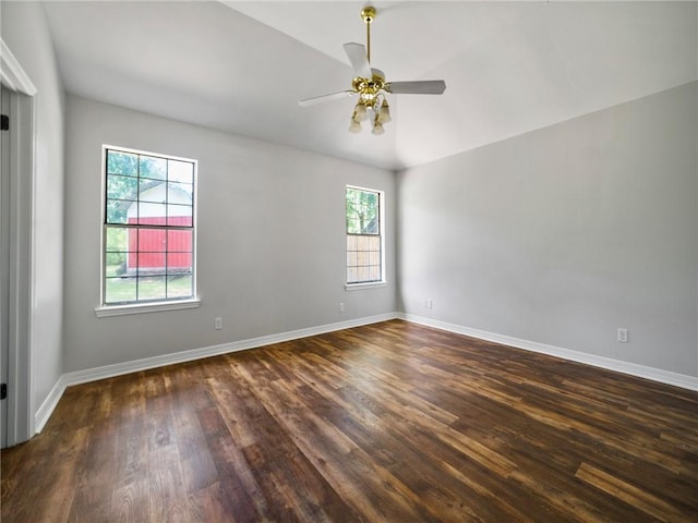 empty room with vaulted ceiling, a wealth of natural light, ceiling fan, and dark hardwood / wood-style floors