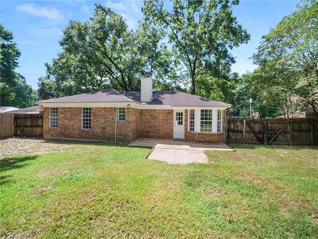 back of property with a yard and a patio