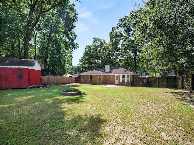 view of yard with a patio area, a storage shed, and an outdoor fire pit