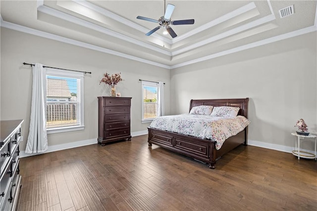 bedroom featuring ceiling fan, crown molding, a raised ceiling, and multiple windows