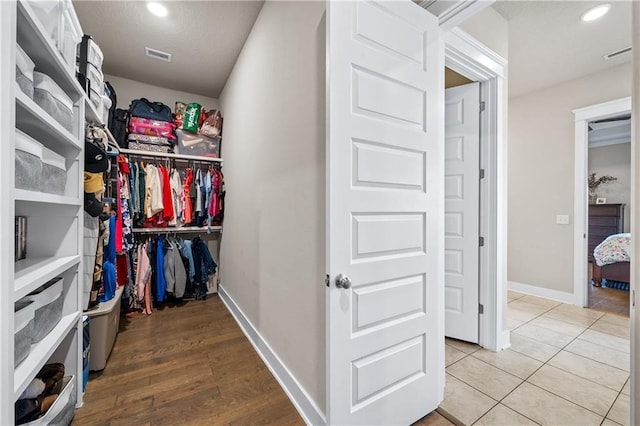 walk in closet with wood-type flooring