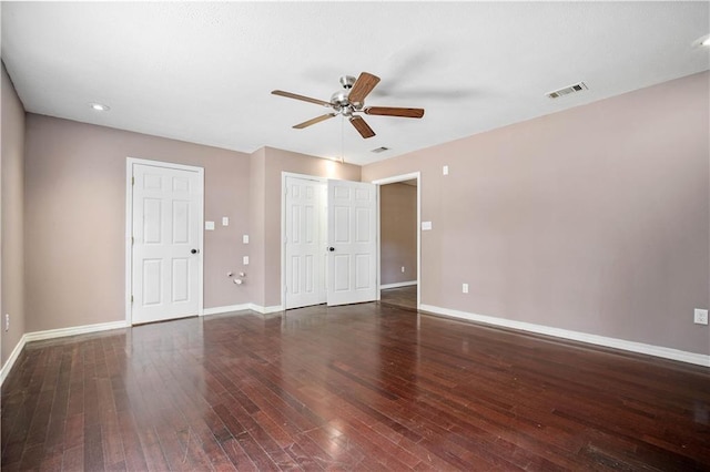 empty room with ceiling fan and dark hardwood / wood-style flooring