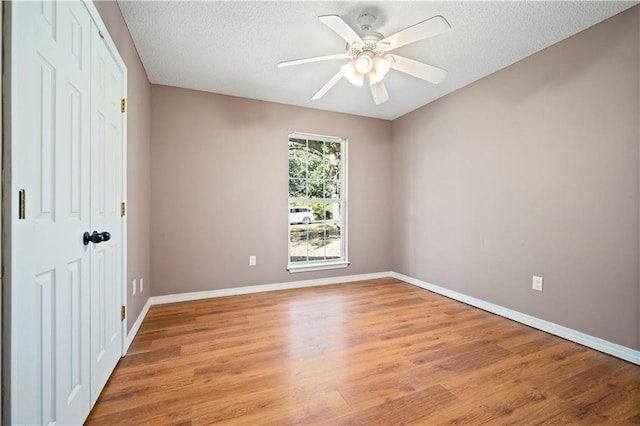 unfurnished bedroom featuring ceiling fan, a closet, light hardwood / wood-style floors, and a textured ceiling