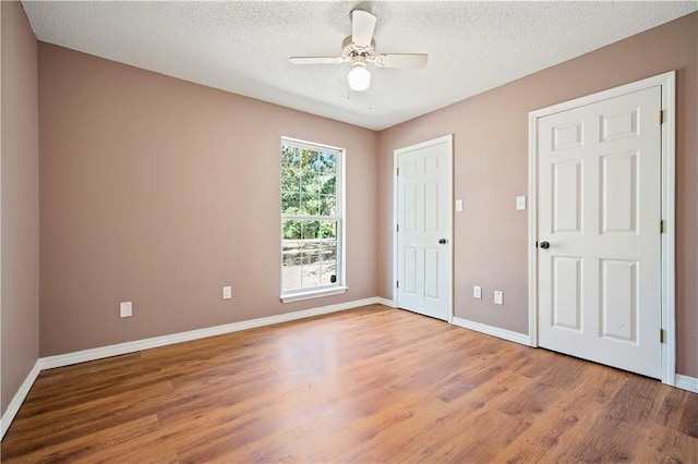 unfurnished bedroom with ceiling fan, wood-type flooring, and a textured ceiling