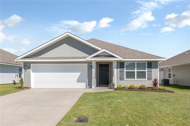 view of front of home featuring cooling unit, a front lawn, and a garage