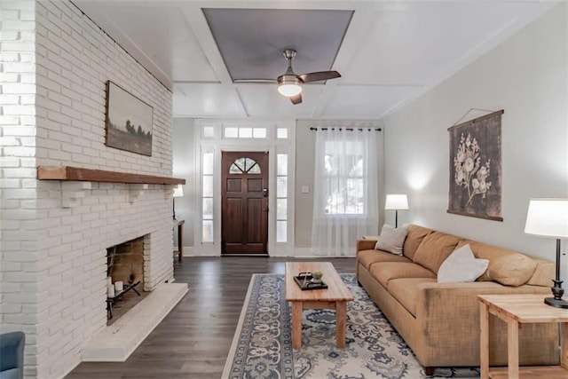 living room featuring a fireplace, ceiling fan, and dark wood-type flooring