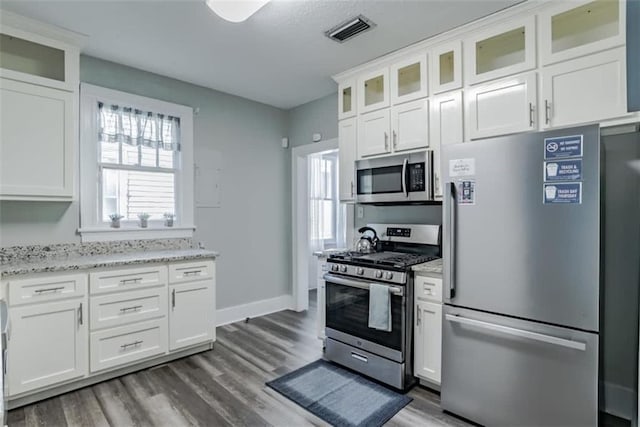 kitchen featuring hardwood / wood-style flooring, white cabinetry, and stainless steel appliances