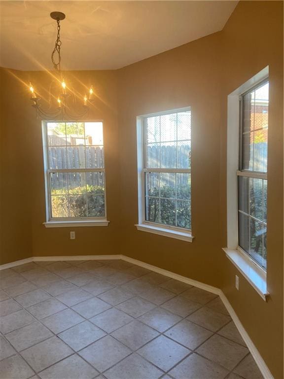 unfurnished dining area featuring tile patterned floors and a chandelier