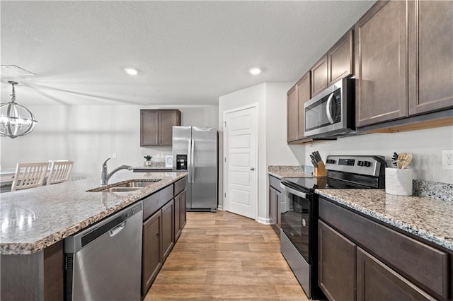 10520 Wales Ln, Spanish Fort, AL 36527 - kitchen with appliances with stainless steel finishes, a sink, dark brown cabinetry, light wood-style flooring, and recessed lighting