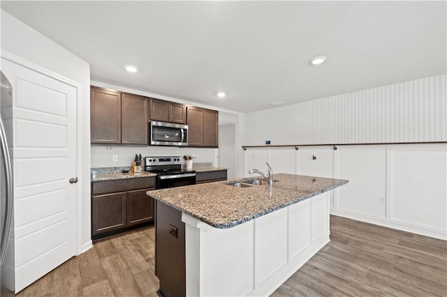 10520 Wales Ln, Spanish Fort, AL 36527 - kitchen with appliances with stainless steel finishes, a sink, light wood finished floors, dark brown cabinets, and recessed lighting