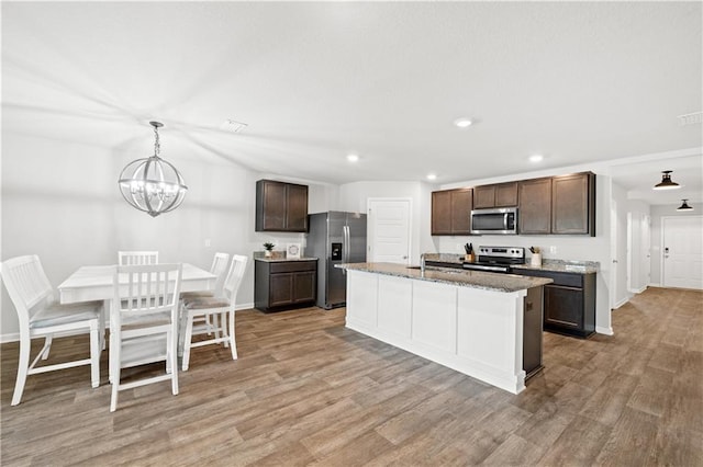 10520 Wales Ln, Spanish Fort, AL 36527 - kitchen with stainless steel appliances, light wood finished floors, a chandelier, dark brown cabinets, and recessed lighting