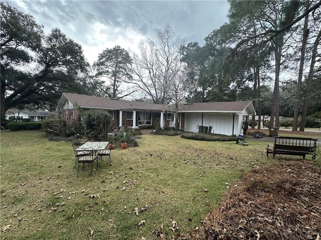 rear view of property featuring a lawn